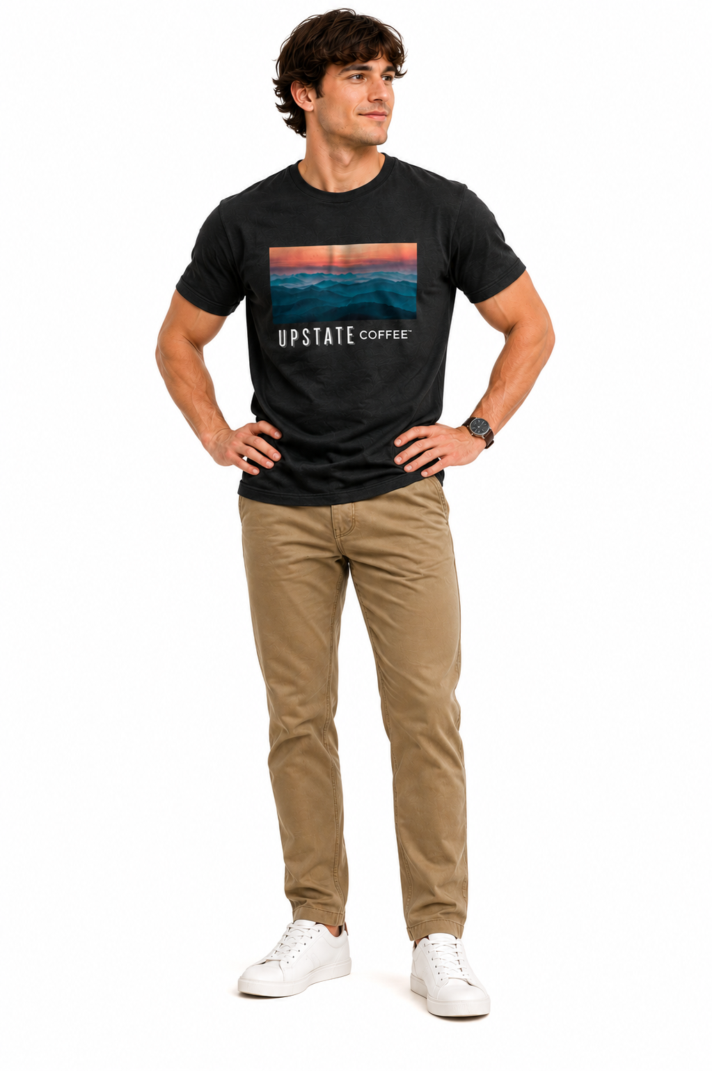 Male model wearing a black tshirt with an upstate coffee mountain scene graphic design and khaki pant on a white backdrop